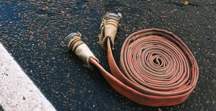 Mangueira de incêndio enrolada, com as conexões nas pontas