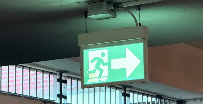 Placa de saída de emergência iluminada, instalada no teto